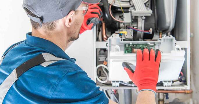 A technician servicing a furnace.